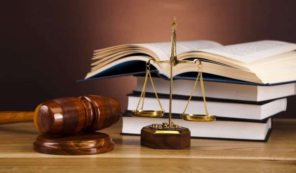 Mazo judicial, balanza y libros jurídicos representando la defensa legal en casos de violencia de género en MNC Legal, Chiclana